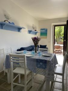 una sala da pranzo con tavolo e panna da tavola blu e bianca di LA FINESTRA SUL MARE - Antonella Apartment a Vieste
