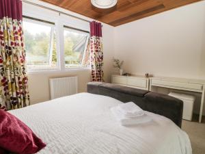 a bedroom with a large bed and a window at Lodge 27 in Bideford