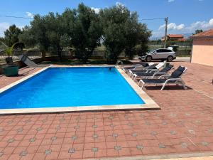 einen Pool mit Liegestühlen und einem Auto in der Unterkunft Villa Paludo in Novigrad