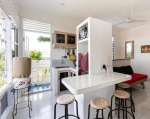 a kitchen with a counter and stools in a room at Beach House Apartment in Legian