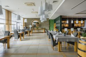 jadalnia ze stołami i krzesłami w restauracji w obiekcie Aroma Stone Hotel Spa w Sycowie