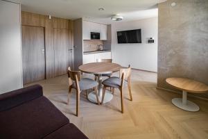uma sala de estar com mesa e cadeiras e uma cozinha em Apartmány Na Zahradách em Lednice