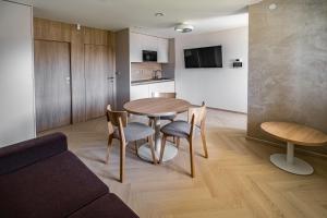 a living room with a table and chairs and a kitchen at Apartmány Na Zahradách in Lednice