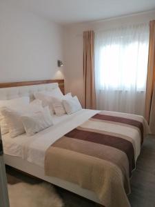 1 dormitorio con 1 cama grande y ventana en APARTMAN MAX !!!!, en Omiš