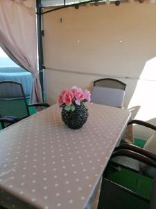 una mesa con un jarrón con flores rosas. en APARTMAN MAX !!!!, en Omiš
