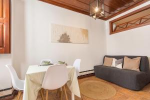 a dining room with a table and a couch at Casa das Tulipas - Vila Nogueira de Azeitão in Villa Nogueira
