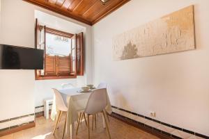 a dining room with a white table and chairs at Casa das Tulipas - Vila Nogueira de Azeitão in Villa Nogueira