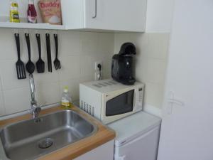 a kitchen with a sink and a microwave at Studio ville très calme in Tarbes