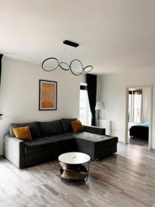 a living room with a black couch and a table at Skylark - Singapore Penthouse with Jacuzzi & Panoramic View in Braşov