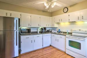 a kitchen with white cabinets and a clock on the wall at Family-Friendly Omaha Home about 5 Mi to Dtwn! in Omaha