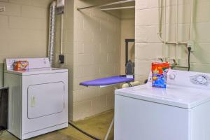 a laundry room with a washing machine and a blue chair at 6 Mi to Old Market Home with BBQ-Ready Patio! in Omaha +21 photos