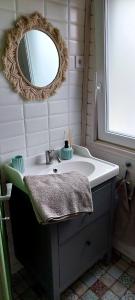 a bathroom with a sink and a mirror at Erdőalján Házikó in Sukoró