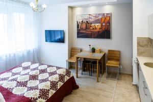 a bedroom with a bed and a dining room table at Hazel Apartment in Vilnius