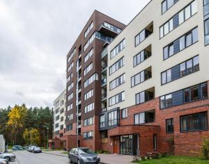 un edificio de apartamentos en una calle con coches aparcados en Hazel Apartment, en Vilna