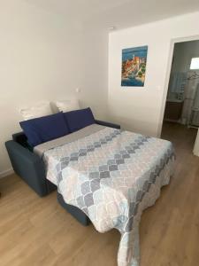 een slaapkamer met een bed met blauwe kussens bij la maison des cigales in Martigues