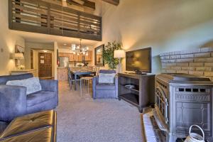 a living room with a couch and a tv and a kitchen at Alpine Meadows Condo with Mtn Views Near Lake Tahoe in Alpine Meadows