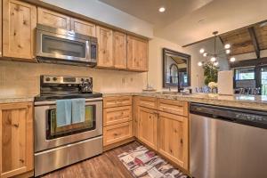 a kitchen with wooden cabinets and stainless steel appliances at Alpine Meadows Condo with Mtn Views Near Lake Tahoe in Alpine Meadows