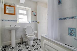 a bathroom with a toilet and a sink and a tub at Leworthy Farmhouse Bed and Breakfast in Holsworthy