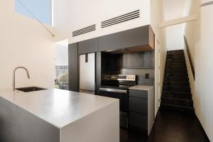 een keuken met witte werkbladen en een trap bij Sonder Ida in Phoenix