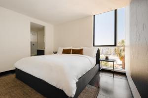 een slaapkamer met een groot wit bed en een raam bij Sonder Ida in Phoenix