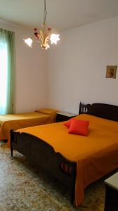 1 Schlafzimmer mit 2 Betten und einem Kronleuchter in der Unterkunft Appartamento Graziella, nel cuore di Ischia Porto in Ischia