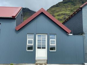 una casa azul con techo rojo y puerta blanca en Rauðafell apartment, en Hvolsvöllur