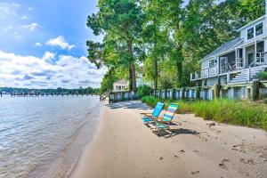 a couple of chairs sitting on a beach next to a house at Bayside Deltaville Retreat with Beach and Bay Views! in Locklies