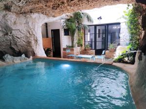 una piscina en una cueva con una casa en la Alhábega, en Villena