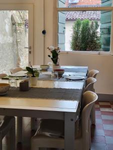 a dining room table with chairs and a table with flowers on it at 19 Borgo Cavour in Treviso