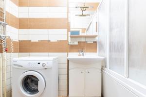 a bathroom with a washing machine and a sink at Old Town Hearh Light and Open Modern Flat VIP in Klaipėda