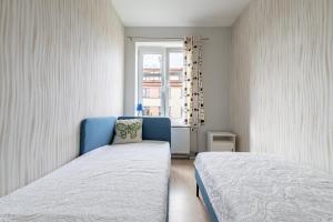 een slaapkamer met 2 bedden en een raam bij Old Town Hearh Light and Open Modern Flat VIP in Klaipėda