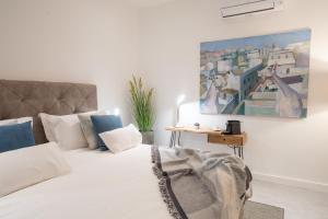 1 dormitorio con 1 cama y una pintura en la pared en Eleven, Boutique luxury house & garden en Boliqueime