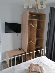 a bedroom with a bed and a tv and shelves at La Tortuga - Vama Veche in Vama Veche