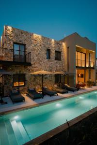 a villa with a swimming pool in front of a building at Capital Luxury Suites in Nafplio