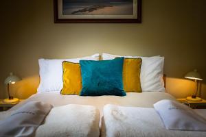 a bed with two pillows on it with two lamps at Cruickshanks Boutique B&B in Whiting Bay