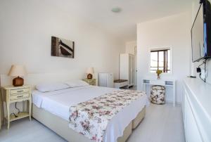 a white bedroom with a bed and a refrigerator at Cesurlar Hotel in Çeşme