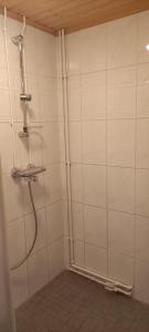 a shower in a bathroom with white tile walls at Asunto Rautatiekatu 4 in Ylivieska