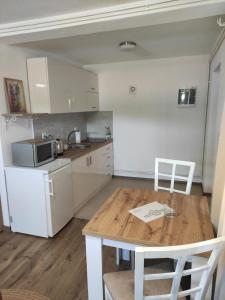 - une cuisine avec une table en bois et des appareils électroménagers blancs dans l'établissement Dream Home Studio Apartments, à Tuzla