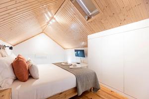 a bedroom with a large bed with a wooden ceiling at Vila Terra Luxury Apartments I in Vila Nova de Gaia