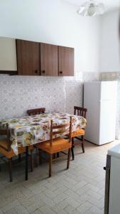 eine Küche mit einem Tisch und Stühlen sowie einem Kühlschrank in der Unterkunft Appartamento Graziella, nel cuore di Ischia Porto in Ischia