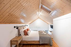 a bedroom with a bed and a wooden ceiling at Vila Terra Luxury Apartments I in Vila Nova de Gaia