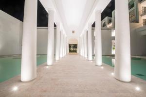 a hallway of a building with columns and a pool at La Badira - Adult Only in Hammamet