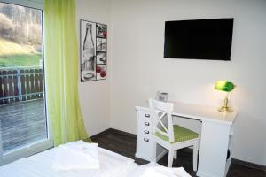 een kamer met een bureau met een stoel en een televisie bij REGIOHOTEL Schanzenhaus Wernigerode in Wernigerode