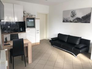 a living room with a couch and a table at KRAICHGAU # 1-ZKD mit EBK, modern und barrierefrei, Monteurzimmer, SELF-CHECK-IN in Ittlingen