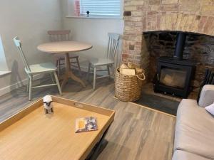 a living room with a couch and a fireplace at Little House in Porlock