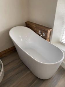 baño con bañera blanca y ventana en Little House, en Porlock