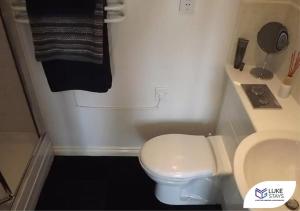 a bathroom with a white toilet and a black towel at Luke Stays - Roundhaven in Brandon