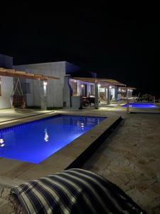 una piscina por la noche frente a un edificio en URUAÚ BEACH RESIDENCE, en Beberibe