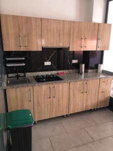 eine Küche mit Holzschränken und einer Arbeitsplatte in der Unterkunft Chez ZAKARIA de Lyon in Meknès