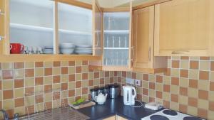 a kitchen with wooden cabinets and a counter top at Coiribe House B&SelfBreakfast in Galway